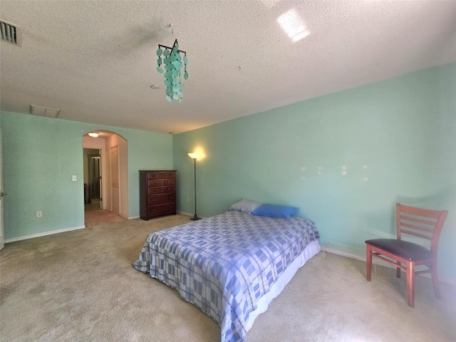 15483 Penn State Rd, Weeki Wachee, FL 34614 - carpeted bedroom featuring arched walkways and a textured ceiling