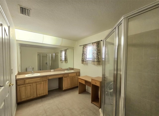 15483 Penn State Rd, Weeki Wachee, FL 34614 - bathroom with double vanity, a shower stall, tile patterned floors, and a textured ceiling