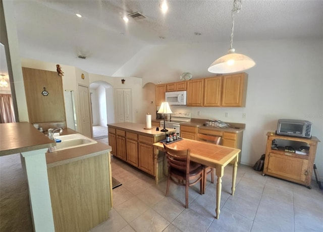 15483 Penn State Rd, Weeki Wachee, FL 34614 - kitchen with arched walkways, white appliances, a kitchen island with sink, vaulted ceiling, and light tile patterned flooring