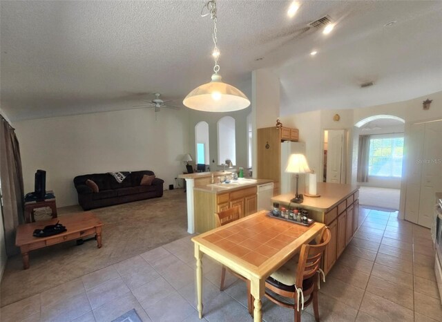 15483 Penn State Rd, Weeki Wachee, FL 34614 - dining area featuring arched walkways, lofted ceiling, light tile patterned flooring, a ceiling fan, and light colored carpet