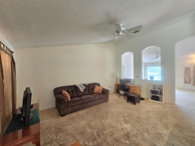 15483 Penn State Rd, Weeki Wachee, FL 34614 - carpeted living area featuring a ceiling fan, a textured ceiling, and arched walkways