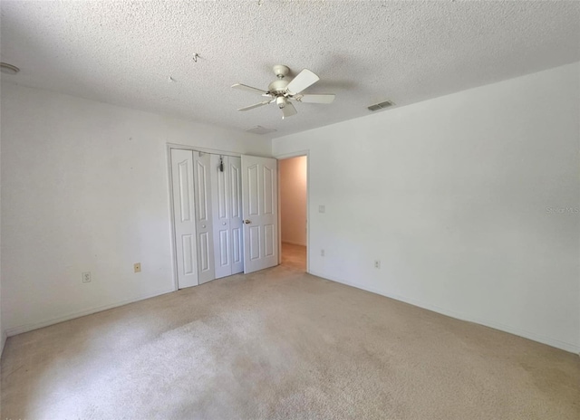 15483 Penn State Rd, Weeki Wachee, FL 34614 - unfurnished bedroom featuring light carpet, a closet, a ceiling fan, and a textured ceiling