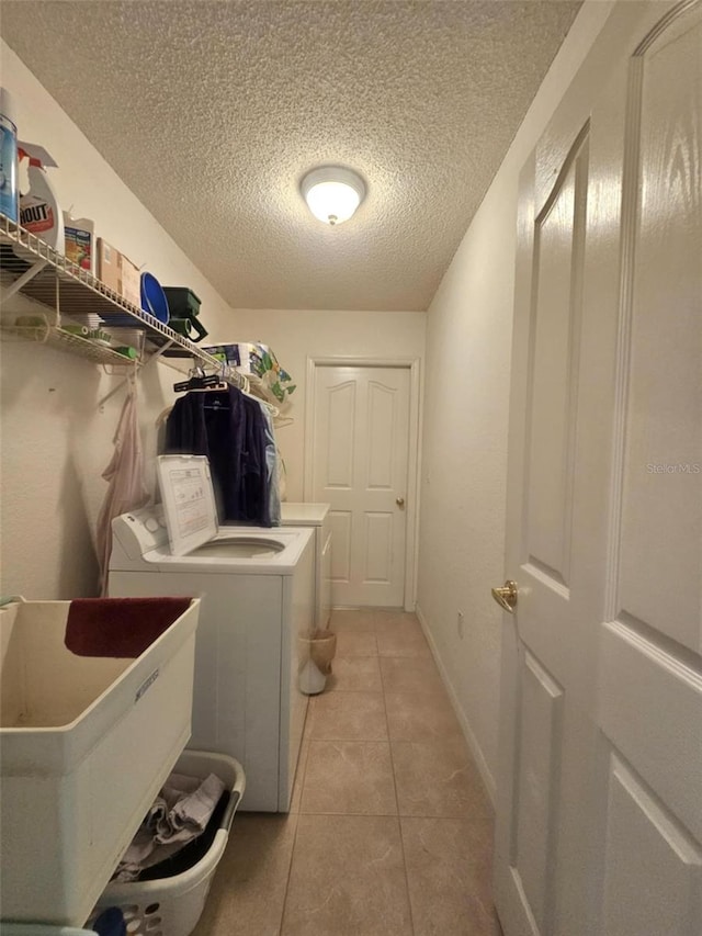15483 Penn State Rd, Weeki Wachee, FL 34614 - laundry area featuring washer and dryer, a textured ceiling, and light tile patterned floors