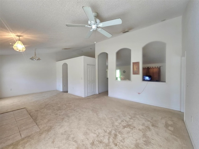 15483 Penn State Rd, Weeki Wachee, FL 34614 - spare room featuring carpet, ceiling fan, a textured ceiling, arched walkways, and vaulted ceiling
