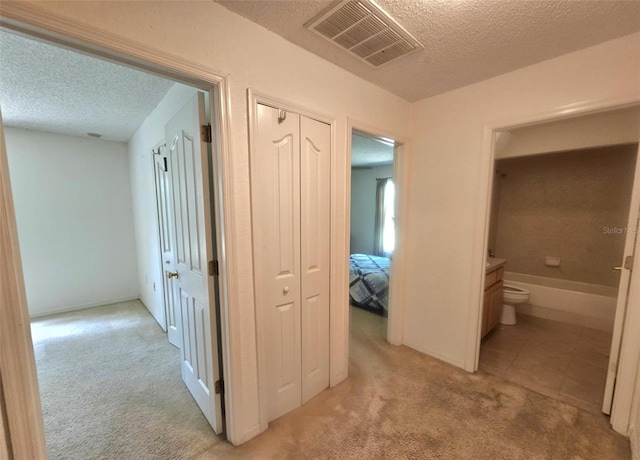 15483 Penn State Rd, Weeki Wachee, FL 34614 - corridor featuring a textured ceiling, light colored carpet, and light tile patterned flooring
