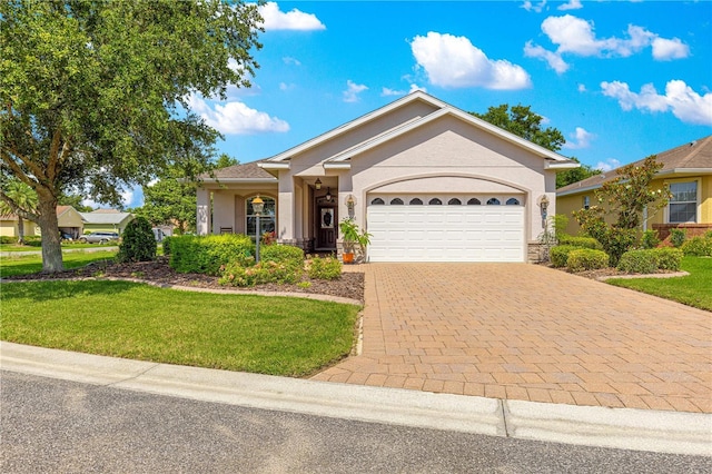 8566 SW 83rd Loop, Ocala, FL 34481 - ranch-style home with stucco siding, a front yard, an attached garage, and decorative driveway