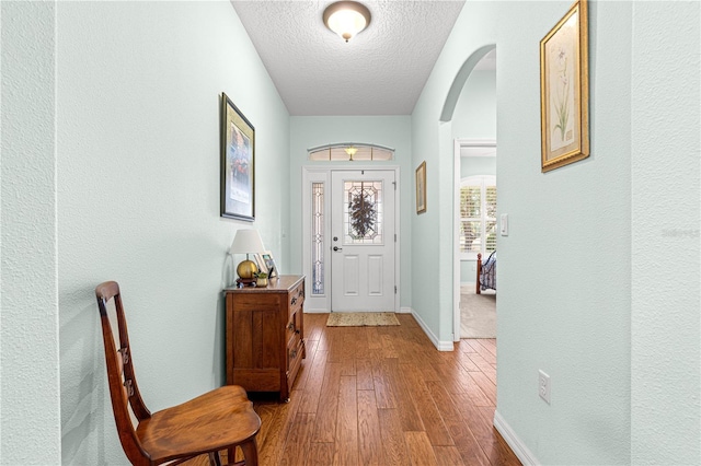 8566 SW 83rd Loop, Ocala, FL 34481 - entryway featuring arched walkways, a textured ceiling, hardwood / wood-style flooring, and a textured wall