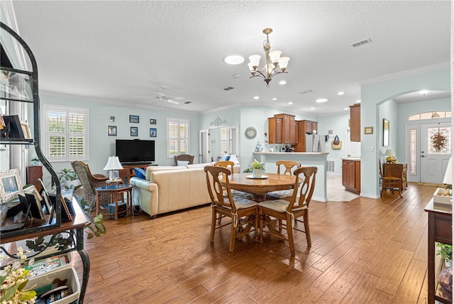 8566 SW 83rd Loop, Ocala, FL 34481 - dining space with arched walkways, ceiling fan, crown molding, light wood finished floors, and a textured ceiling