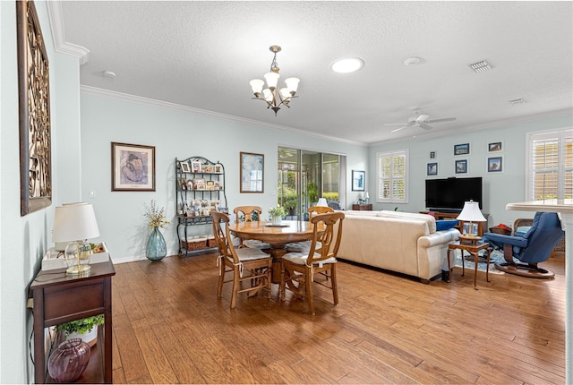 8566 SW 83rd Loop, Ocala, FL 34481 - dining area with ornamental molding, wood finished floors, plenty of natural light, a chandelier, and a textured ceiling