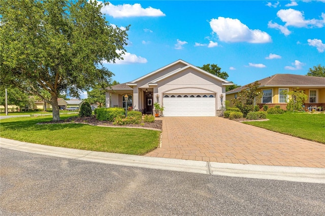 8566 SW 83rd Loop, Ocala, FL 34481 - ranch-style house with a garage, a front lawn, decorative driveway, and stucco siding