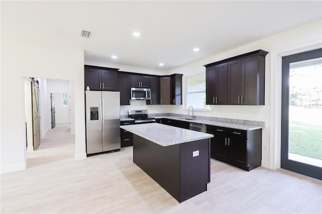 7 Hill Prince Dr, Ocala, FL 34482 - kitchen featuring stainless steel appliances, plenty of natural light, a kitchen island, light stone countertops, and recessed lighting