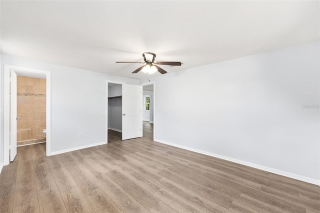 14761 SW 35th Terrace Rd, Ocala, FL 34473 - unfurnished bedroom with wood finished floors, a walk in closet, a closet, and ensuite bathroom
