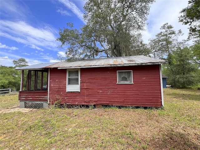 23161 NE 155th Ct, Fort Mc Coy, FL 32134 - view of home's exterior with a metal roof, a lawn, and a sunroom