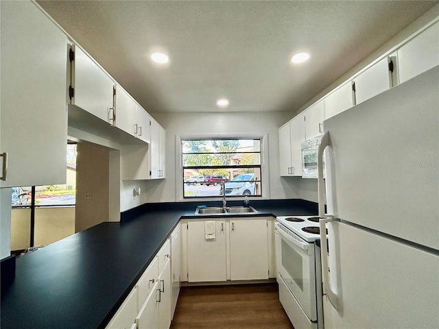 3525 E Fort King St Unit 145, Ocala, FL 34470 - kitchen with white appliances, dark countertops, recessed lighting, dark wood finished floors, and white cabinetry