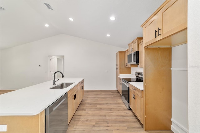 5400 NW 9th St, Ocala, FL 34482 - kitchen with appliances with stainless steel finishes, light brown cabinetry, a center island with sink, light wood-style flooring, and lofted ceiling