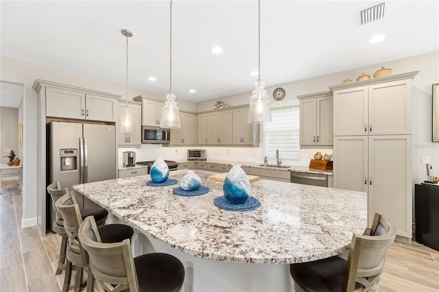 4340 NW 56th Ct, Ocala, FL 34482 - kitchen with appliances with stainless steel finishes, a kitchen breakfast bar, light stone countertops, a spacious island, and recessed lighting
