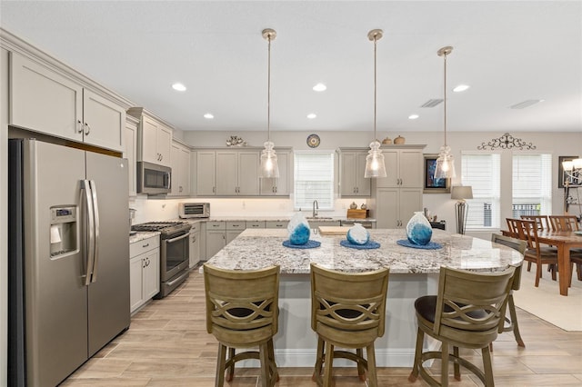 4340 NW 56th Ct, Ocala, FL 34482 - kitchen with appliances with stainless steel finishes, a kitchen breakfast bar, a kitchen island, recessed lighting, and hanging light fixtures