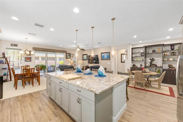 4340 NW 56th Ct, Ocala, FL 34482 - kitchen featuring a kitchen island, light wood finished floors, light stone countertops, open floor plan, and recessed lighting