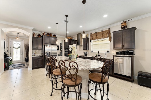 9634 SW 67th St, Ocala, FL 34481 - kitchen with stainless steel appliances, decorative backsplash, crown molding, dark brown cabinetry, and a breakfast bar area