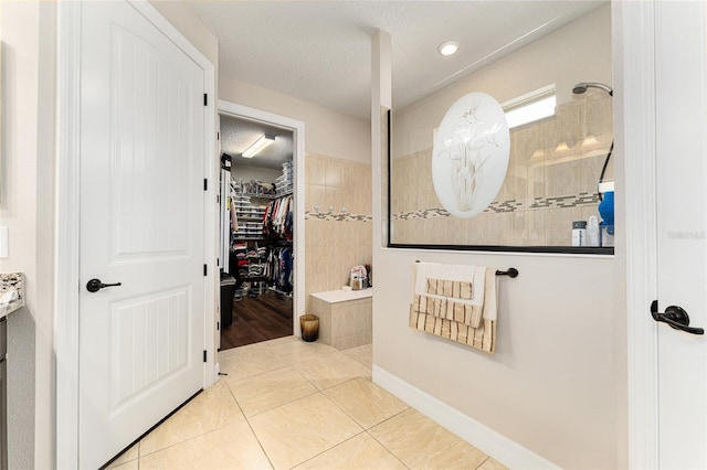 9634 SW 67th St, Ocala, FL 34481 - bathroom with walk in shower, a walk in closet, tile patterned flooring, recessed lighting, and a textured ceiling