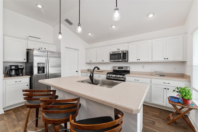 4416 Homan Loop, The Villages, FL 32163 - kitchen featuring appliances with stainless steel finishes, lofted ceiling, an island with sink, dark wood-style flooring, and white cabinets