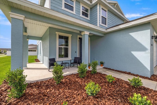 7695 SW 64th Street Rd, Ocala, FL 34474 - view of exterior entry with covered porch and stucco siding