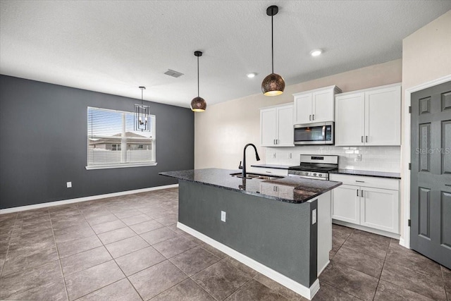 7695 SW 64th Street Rd, Ocala, FL 34474 - kitchen featuring stainless steel appliances, backsplash, white cabinetry, an island with sink, and a textured ceiling