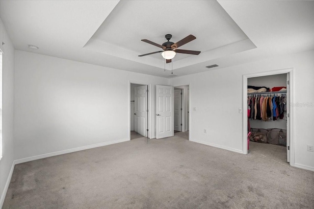 7695 SW 64th Street Rd, Ocala, FL 34474 - unfurnished bedroom featuring a tray ceiling, carpet floors, a walk in closet, and a closet