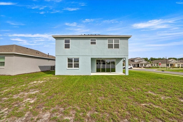 7695 SW 64th Street Rd, Ocala, FL 34474 - rear view of house featuring stucco siding, a lawn, and a patio