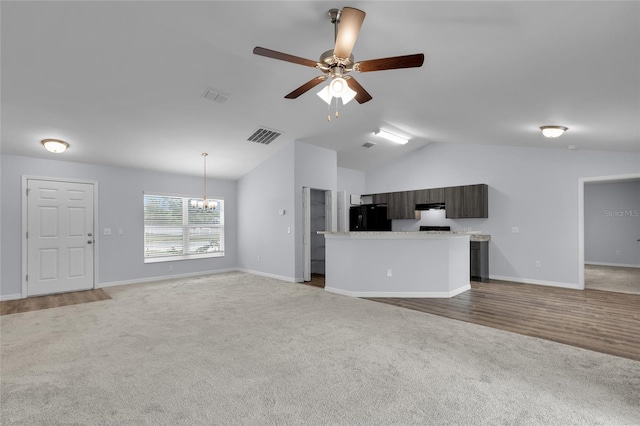 4501 SW 159th Street Rd, Ocala, FL 34473 - unfurnished living room featuring light colored carpet, lofted ceiling, a chandelier, and a ceiling fan