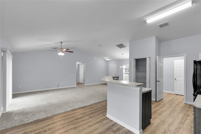 4501 SW 159th Street Rd, Ocala, FL 34473 - kitchen featuring a ceiling fan, vaulted ceiling, light wood-style flooring, light countertops, and a kitchen island