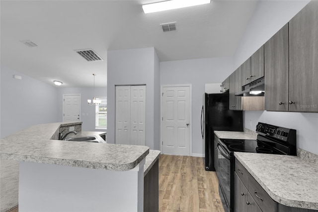 4501 SW 159th Street Rd, Ocala, FL 34473 - kitchen with black appliances, under cabinet range hood, light countertops, light wood-type flooring, and a kitchen island with sink