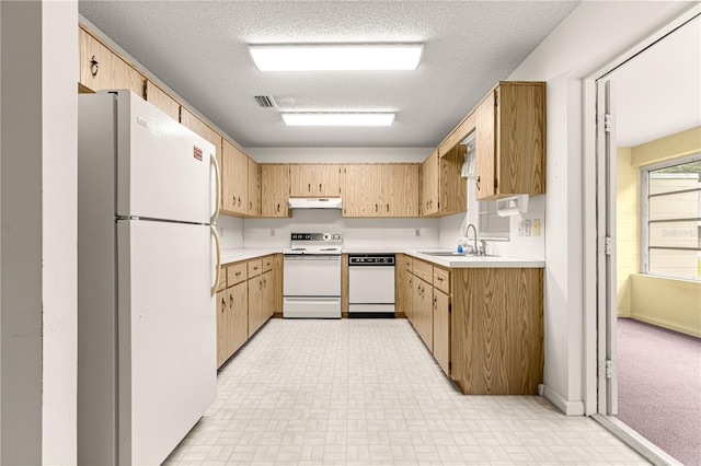 9367 SW 83rd Ave Unit C, Ocala, FL 34481 - kitchen with white appliances, light countertops, under cabinet range hood, and a textured ceiling