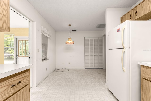 9367 SW 83rd Ave Unit C, Ocala, FL 34481 - kitchen featuring freestanding refrigerator, light countertops, brick patterned floors, and hanging light fixtures