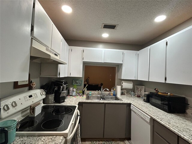 3525 E Fort King St Unit 140, Ocala, FL 34470 - kitchen with white appliances, under cabinet range hood, a textured ceiling, recessed lighting, and white cabinetry