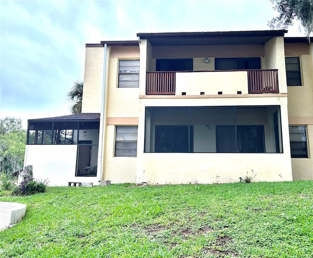 3525 E Fort King St Unit 140, Ocala, FL 34470 - back of house featuring a balcony, stucco siding, and a lawn