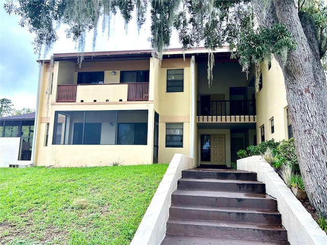 3525 E Fort King St Unit 140, Ocala, FL 34470 - back of house with stucco siding, a lawn, and a balcony