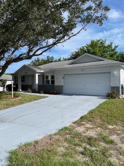9711 SW 97th Pl, Ocala, FL 34481 - single story home with a garage, concrete driveway, and stucco siding
