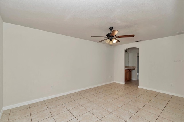 15711 SW 52nd Avenue Rd, Ocala, FL 34473 - unfurnished room featuring arched walkways, ceiling fan, light tile patterned floors, and a textured ceiling