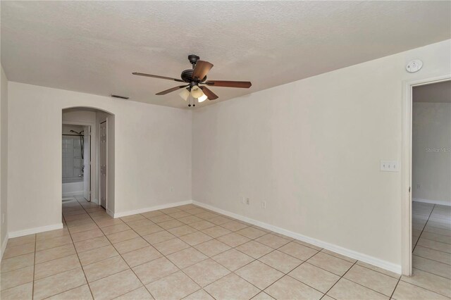 15711 SW 52nd Avenue Rd, Ocala, FL 34473 - spare room with arched walkways, a ceiling fan, a smoke detector, light tile patterned floors, and a textured ceiling