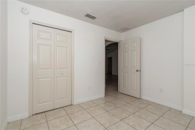 15711 SW 52nd Avenue Rd, Ocala, FL 34473 - unfurnished bedroom featuring arched walkways, light tile patterned flooring, and a closet