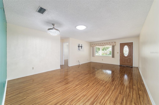 8881 SW 94th St Unit E, Ocala, FL 34481 - unfurnished living room featuring light wood finished floors and a textured ceiling