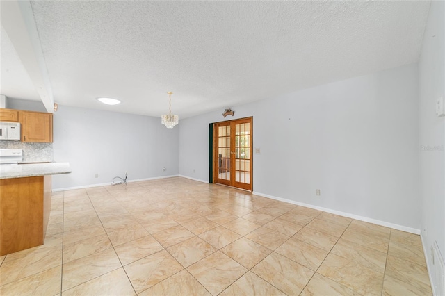 8881 SW 94th St Unit E, Ocala, FL 34481 - unfurnished living room featuring a textured ceiling and a chandelier