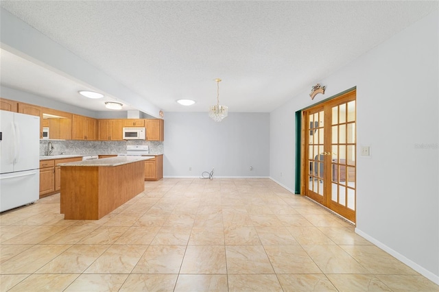 8881 SW 94th St Unit E, Ocala, FL 34481 - kitchen with white appliances, french doors, light countertops, a kitchen island, and decorative backsplash