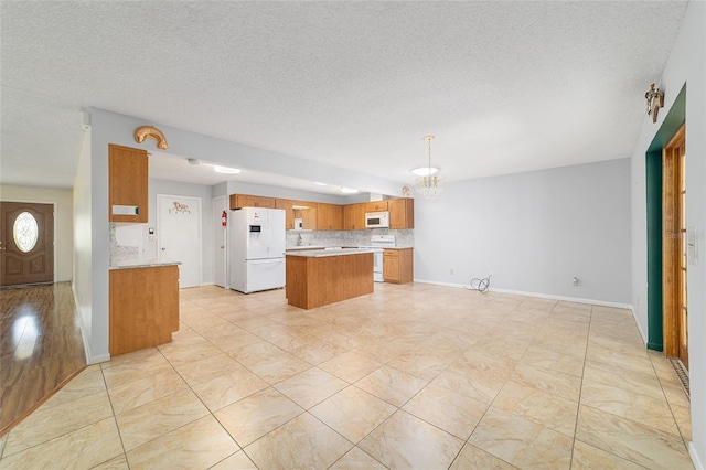 8881 SW 94th St Unit E, Ocala, FL 34481 - kitchen with white appliances, a chandelier, brown cabinets, light countertops, and a textured ceiling