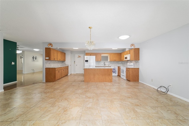 8881 SW 94th St Unit E, Ocala, FL 34481 - kitchen featuring white appliances, a chandelier, backsplash, light countertops, and a kitchen island