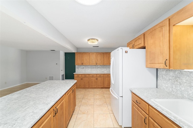 8881 SW 94th St Unit E, Ocala, FL 34481 - kitchen featuring backsplash, light countertops, freestanding refrigerator, and light marble finish flooring