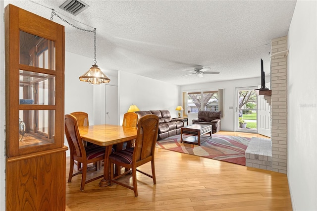 8850 SW 97th St Unit C, Ocala, FL 34481 - dining room featuring a textured ceiling, light wood-style flooring, and a ceiling fan