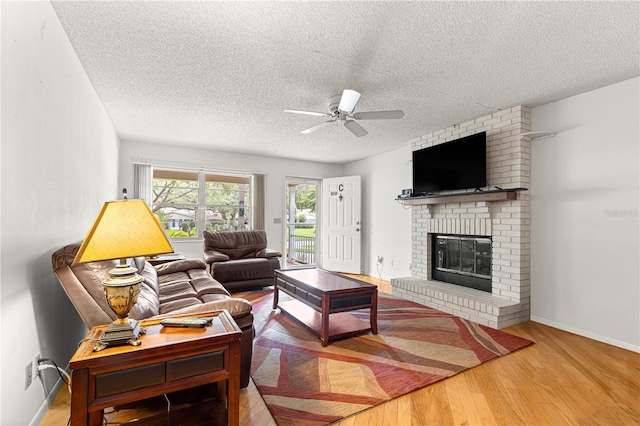 8850 SW 97th St Unit C, Ocala, FL 34481 - living area with a textured ceiling, ceiling fan, wood finished floors, and a fireplace