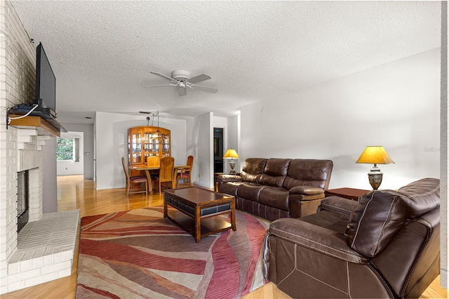 8850 SW 97th St Unit C, Ocala, FL 34481 - living area with a ceiling fan, a textured ceiling, light wood finished floors, and a brick fireplace